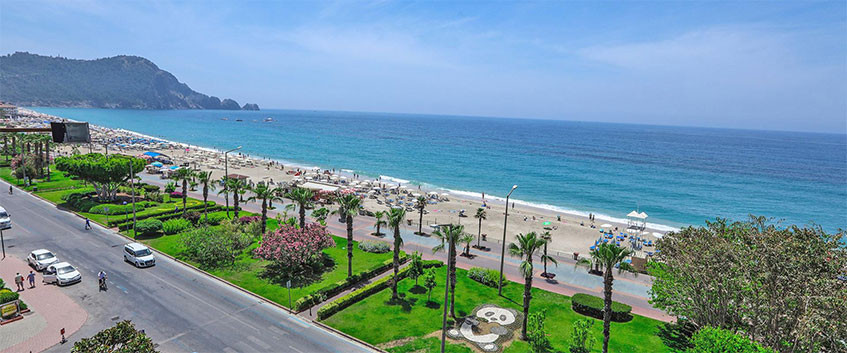 Kleopatra-stranden i Alanya med gyllen sand, turkis vann og Alanya slott
